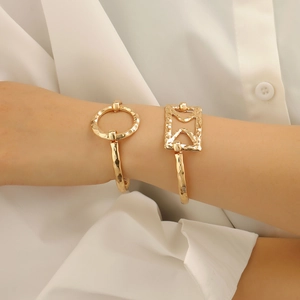 Detail showing irregular hammered gold bangles with geometric circle and rectangle shapes
