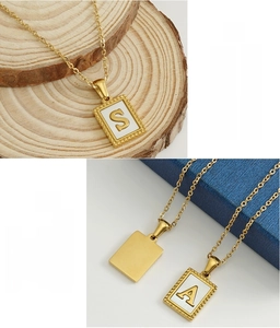 Detail of 18K gold plated stainless steel square pendant necklaces with letters S and A