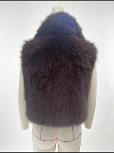 Back view of a deep brown faux fur vest with long plush texture on a mannequin stand