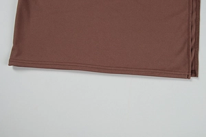 Détail de l'ourlet en tissu marron avec double couture de qualité et texture fine