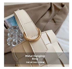 Close-up of cream white woven leather bucket bag with a decorative gold metal ring handle