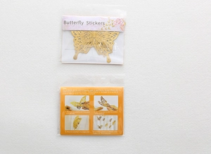 Detail view of gold butterfly stickers set with instruction manual and clear packaging