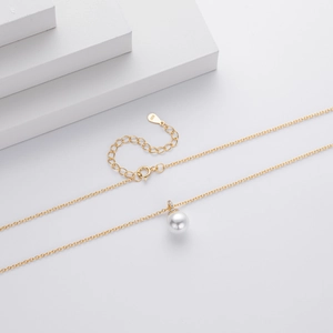 Macro detail of S925 hallmark on a minimalist gold pearl necklace with zircon accents