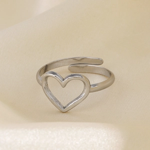 Polished silver heart hollow open ring on champagne silk background, elegant design