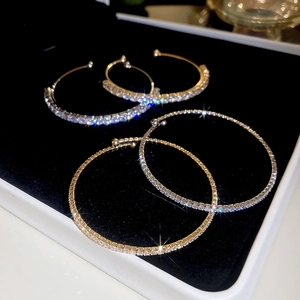 Macro shot of minimalist gold and silver open bracelets with sparkling pavé rhinestones
