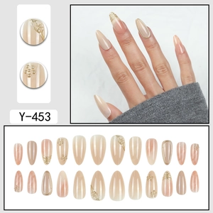 Faux ongles amande rose nude avec motif marbré, fils dorés 3D et détails perles