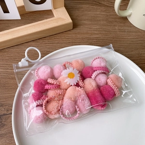 Pink plush pom-pom hair ties set in a transparent zipper bag with floral patterns