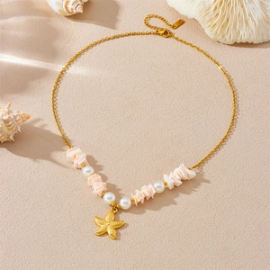 Bohemian gold starfish necklace with pink shell and pearl beads on beach texture