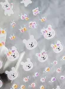 Detailed macro view of thin adhesive nail stickers with purple bears and floral patterns