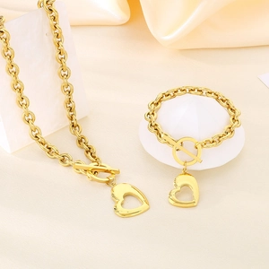 Dettaglio del set collana e bracciale con cuore dorato e chiusura a levetta su seta