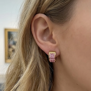 Macro detail of wide 18K gold-plated hoop earring with pink pavé-set crystals