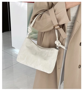 Detailed close-up of ivory tote bag featuring textured fabric and thick rope knot strap