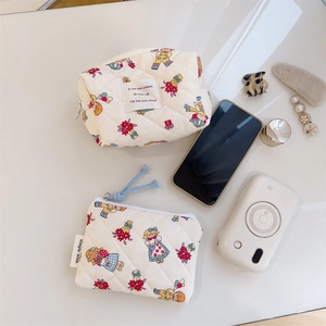 Flat lay of floral quilted makeup pouch and coin purse with soft cotton texture