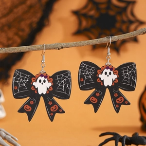 Halloween ghost and pumpkin pattern bow earrings displayed on a dark branch