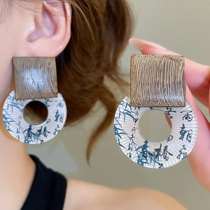 Detail view of ethnic style vintage wood and resin square earrings with bamboo ink patterns