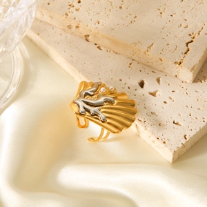 Two-tone gold and silver coral shell ring with white pearls on elegant silk background