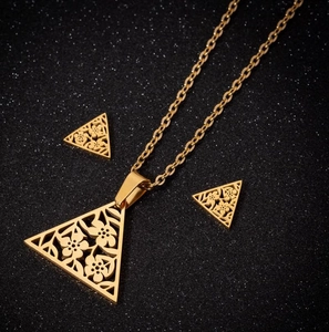 Gold stainless steel jewelry set featuring hollow floral triangle pendant and earrings