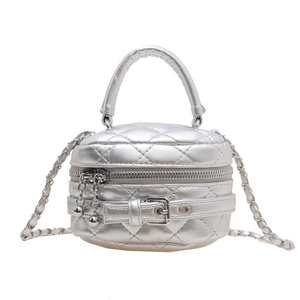 Zilveren gewatteerde mini cilindrische crossbody tas met kettingriem op een witte achtergrond
