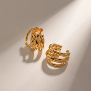 Detailed view of polished 18K gold-plated stainless steel triple layered ear cuffs
