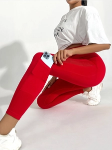 Détail de legging de yoga rouge taille haute montrant la poche latérale pour téléphone