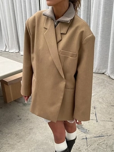 Detail of camel oversized blazer featuring padded shoulders and premium side slit design