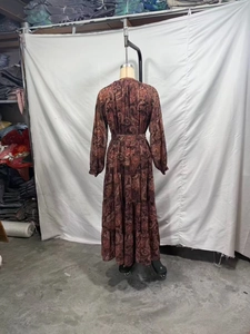 Detail view of paisley print dress with tiered skirt and elastic waist in dark tones