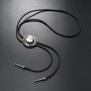 Detail of silver cowboy hat slider and black braided cord on a western bolo tie
