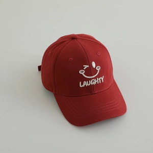 Close-up of red cotton baseball cap with white LAUGHTY smile embroidery and stitching