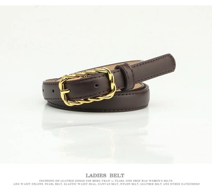 Close-up of dark brown leather belt with decorative gold-tone twisted metal buckle detail
