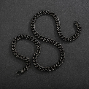 Macro view of black stainless steel Cuban link chain necklace with polished metal finish