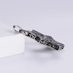 Macro side view of vintage silver hexagram pendant with black engraved textures on white stand