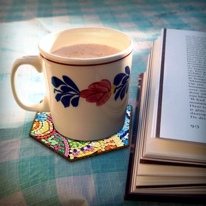 DIY hexagonal wood diamond painting coaster on a cozy table setting with coffee and book