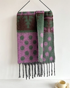 Detail of color-block scarf featuring green, purple, brown geometric dots and black tassels