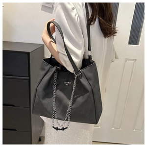 Close-up of black tote bag with silver chain straps and Toxthkness Bags lettering print