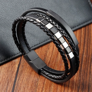 Men's double-layered braided black leather bracelet with magnetic steel clasp on wood