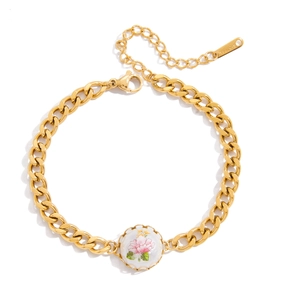 Detailed macro shot of gold-plated stainless steel cuban link bracelet with floral pendant