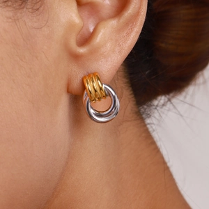 Interlocked gold and silver geometric stainless steel hoop earrings on model ear