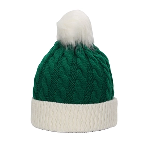 Detail of green knitted Christmas hat featuring white faux fur pompom and cable stitch texture