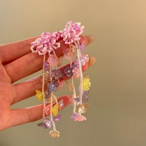 Detailed view of colorful beaded flower tassel earrings for a resort style look.