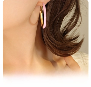 Detail of 18K gold plated hoop earrings with pink enamel on a model side profile