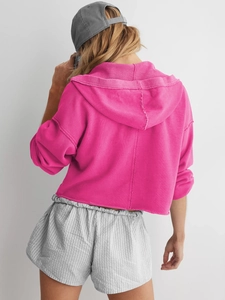 Rückansicht eines trendigen rosa Cropped-Kapuzenpullovers aus weicher Strickbaumwolle