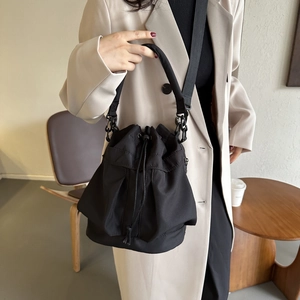 Sac seau en tissu Oxford noir avec cordon de serrage, porté à l'épaule en situation réelle