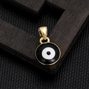 Detail of a round gold-plated evil eye charm with black and white enamel finish