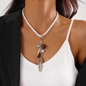 Bohemian necklace featuring silver feathers, wooden beads, and sun charm on white rope