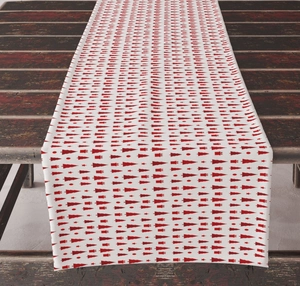 Detail of red geometric Christmas tree pattern on white fabric table runner for holiday decor