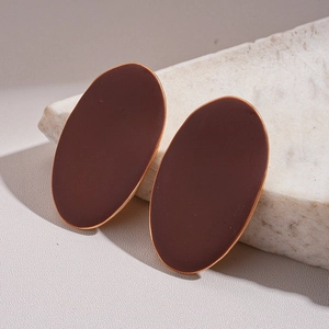 Detailed view of geometric oval stud earrings in reddish-brown enamel with gold edging