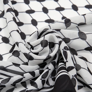 Close-up of white chiffon scarf with black geometric pattern showing soft fabric texture