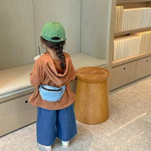 Kids casual denim waist bag in light blue shown on a child in modern lounge setting