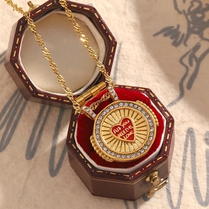 Detailed shot of 18K gold plated necklace with a red heart pendant in a vintage jewelry box