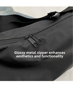 Detail of smooth metal double zippers and durable waterproof fabric on black crossbody bag